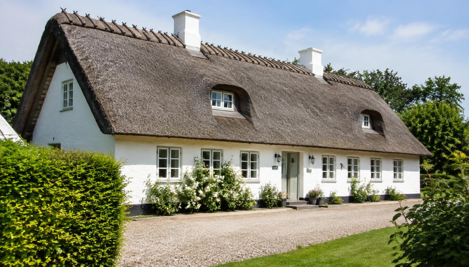 Hvidkalket dansk landhus med stråtag